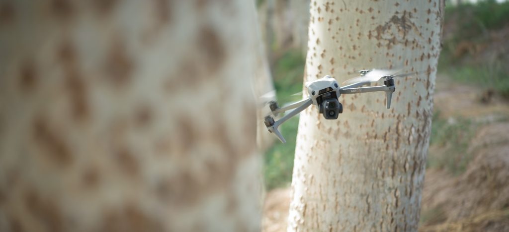 DJI Air 3S fliegt zwischen Bäumen